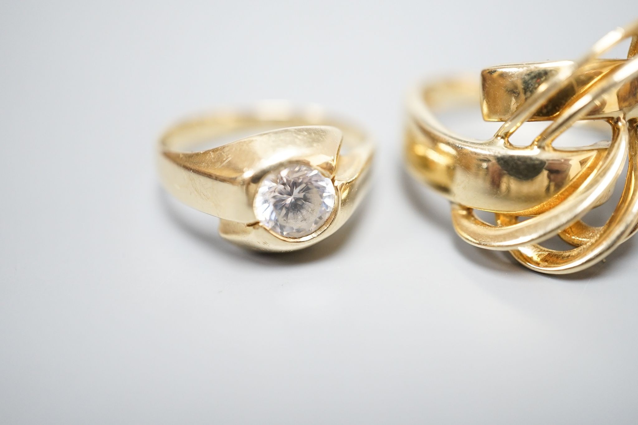 An Italian 750 scroll ring, size P, 5.5 grams and a 585 and white stone ring, gross 3.9 grams.